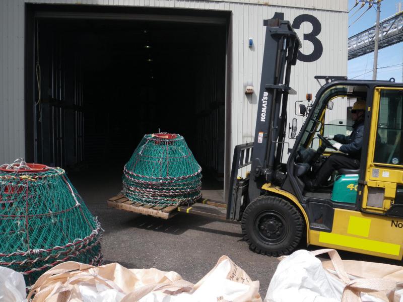 かにかごをフォークリフトで倉庫に搬入する様子