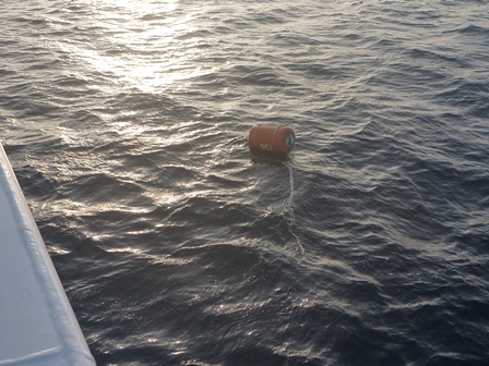 海上に浮かぶオレンジ色で円柱状の浮き