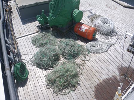 甲板上に置かれた網、ロープ及びオレンジ色で円柱状の浮き